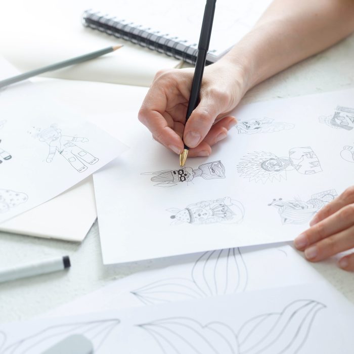 Animator designer draws sketches of various characters. Creating illustrations on paper for cartoons or video games.